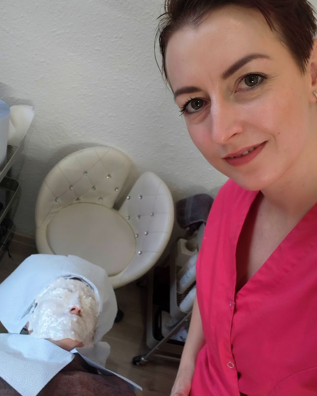 Pavlína v kosmetickém studiu, v pozadí klientka s pleťovou maskou